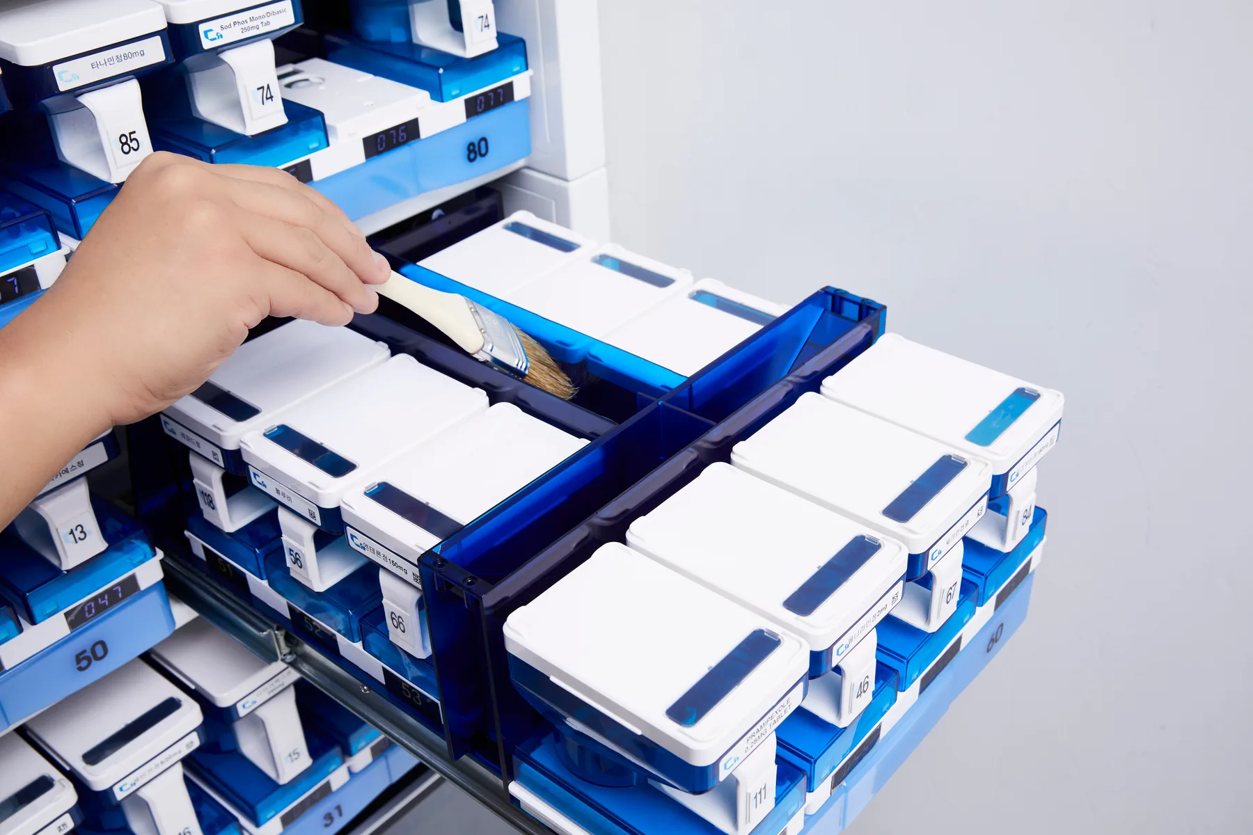 Technician brushing a drug cassette on the extended drawer